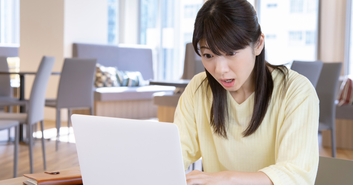 少し驚いた表情でノートパソコンの画面を見つめる女性