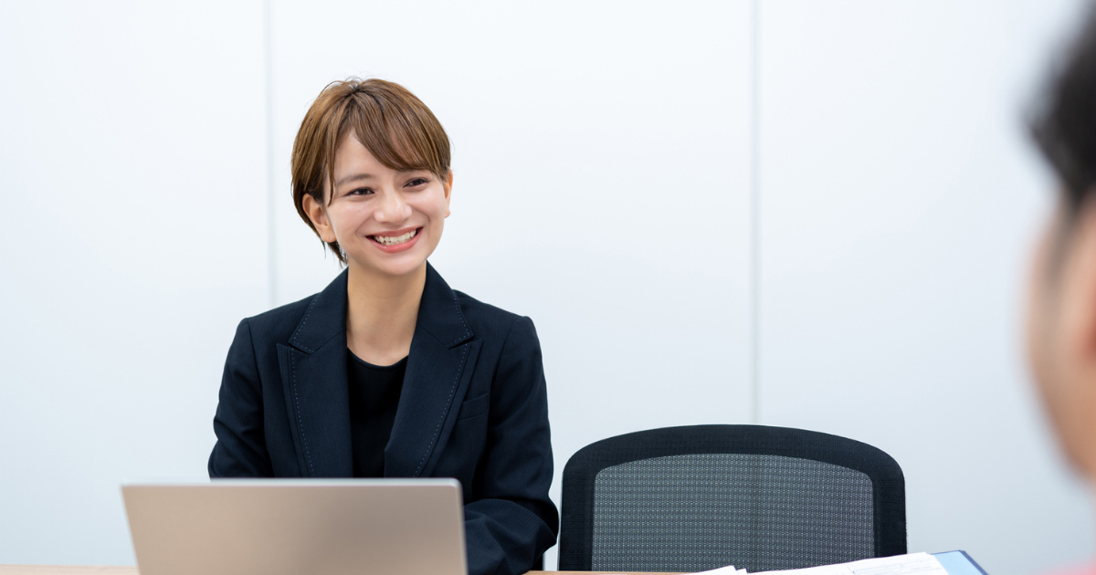 オフィスで向かい合って打ち合わせをする二人のビジネスパーソン