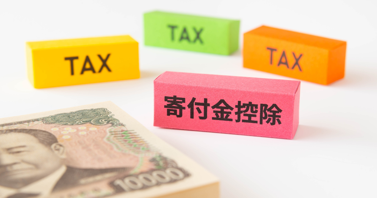 「TAX」と書かれた3つのブロック（黄・緑・オレンジ）と「寄付金控除」と書かれたピンク色のブロック、および一万円札