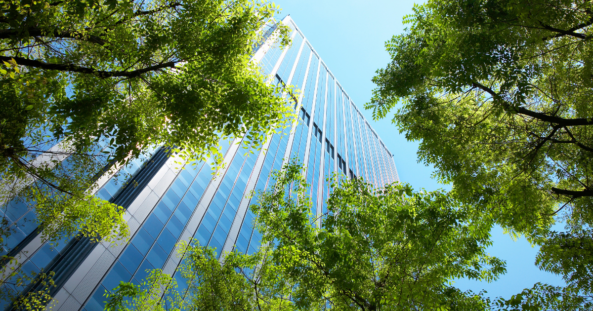 モダンなガラス張りのビルと緑の木々