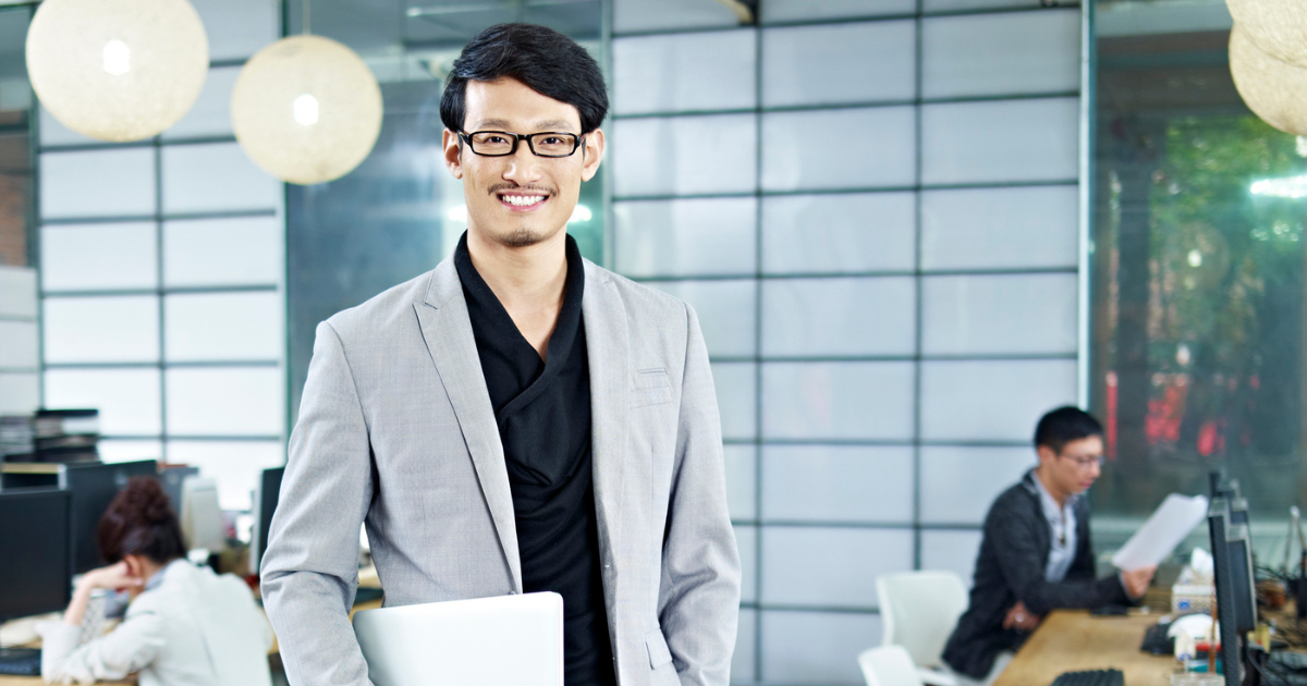 オフィスで微笑むジャケット姿の男性