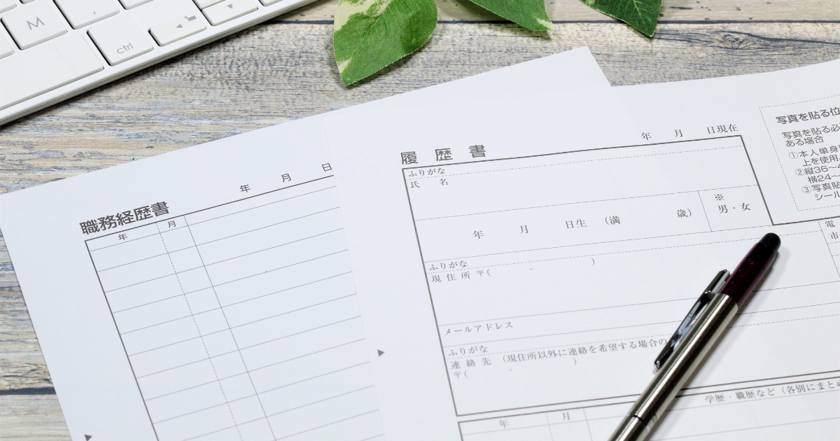 デスクの上に置かれた白紙の履歴書とボールペン